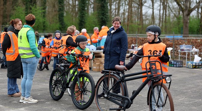 Wethouder Sterenborg met leerlingen in oranje hesjes