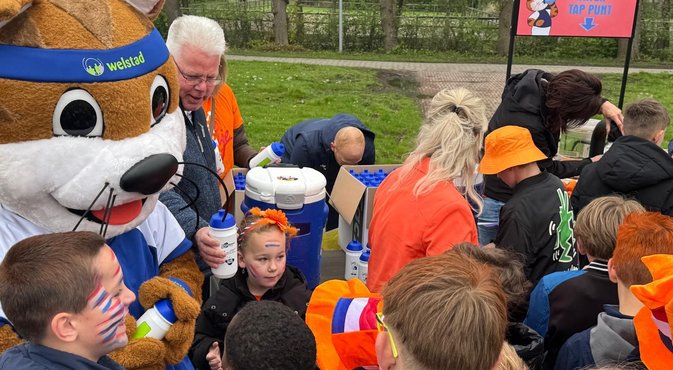 Wethouder Verschuren deelt bidons uit aan basisschoolkinderen