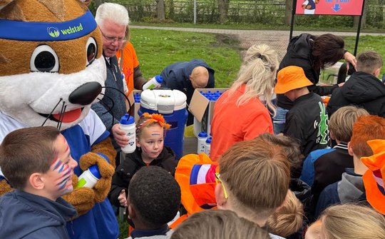 Wethouder Verschuren deelt bidons uit aan basisschoolkinderen