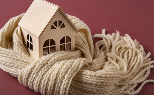 Afbeelding houten huis met sjaal