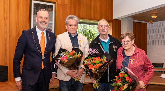 Foto van de gedecoreerden naast de burgemeester