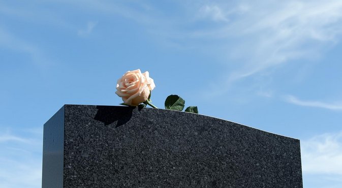 Foto: Grafsteen met daarop een roos
