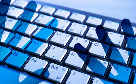 Foto van toetsenbord met schaduw van handen eroverheen