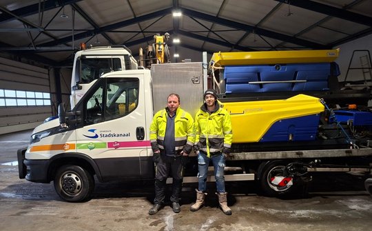 Foto van Sebastiaan en Jordy voor de auto's van gladheidsbestrijding