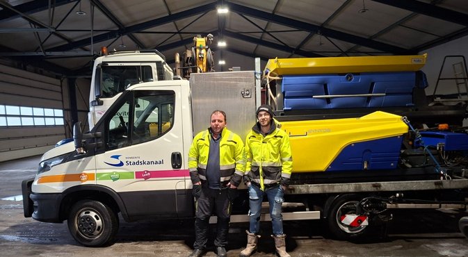 Foto van Sebastiaan en Jordy voor de auto's van gladheidsbestrijding